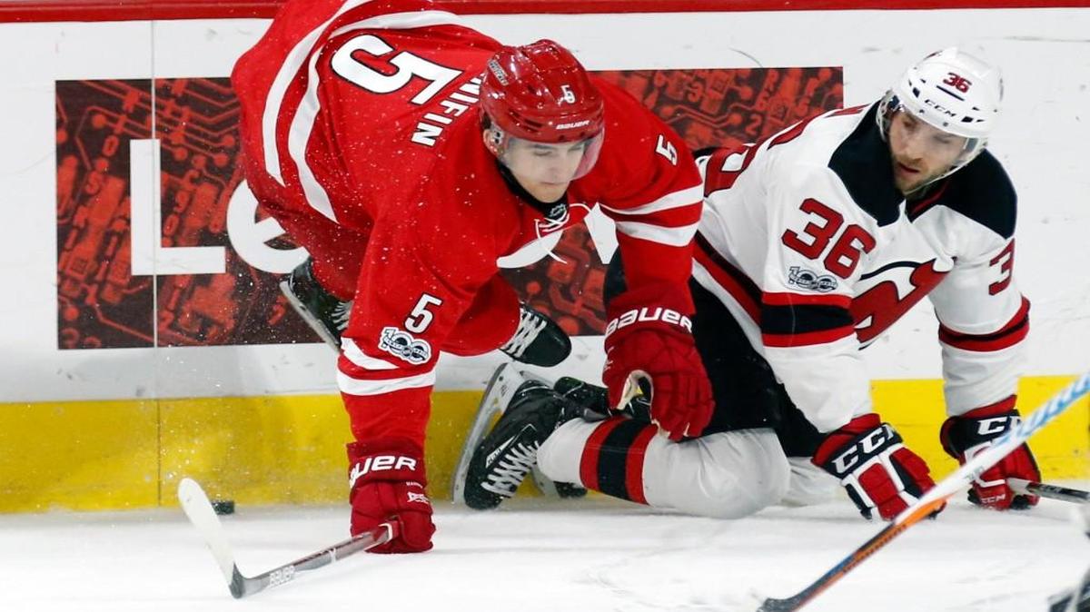 The Carolina Hurricanes' Noah Hanifin (5) gets upended as he battles the New Jersey Devils' Nick Lappin (36) for the puck during the first period of an NHL game played between the Carolina Hurricanes and the New Jersey Devils at PNC Arena in Raleigh, N.C. on Jan. 3, 2017.