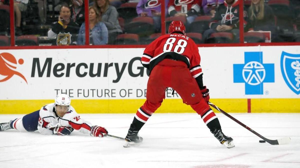 The Caps' Madison Bowey (22) slides to defend the Canes' Martin Necas (88) during the first period of a preseason NHL game played between the Carolina Hurricanes and the Washington Capitals at PNC Arena in Raleigh, N.C. on Sept. 29, 2017. The Canes beat the Caps 3-1.