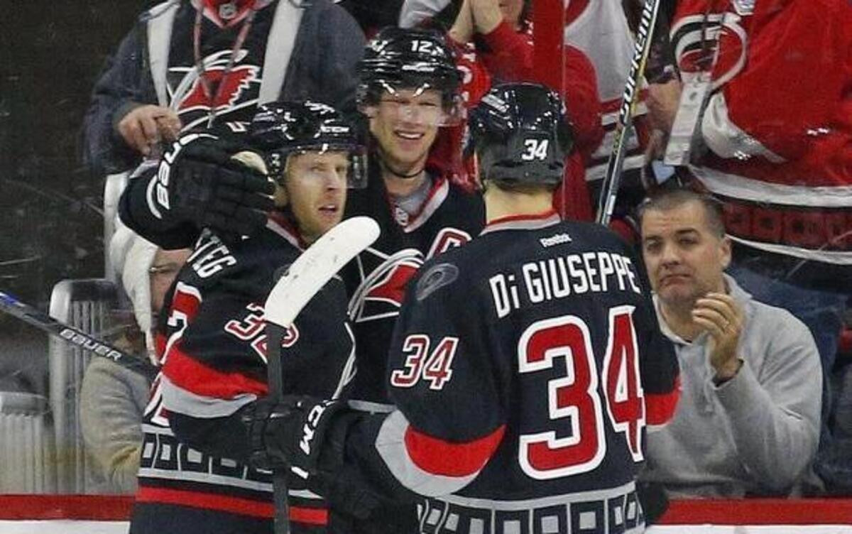 The Carolina Hurricanes' Kris Versteeg (32) celebrates his goal with Eric Staal (12) and Phil Di Giuseppe (34) during the second period against the Calgary Flames at PNC Arena in Raleigh.