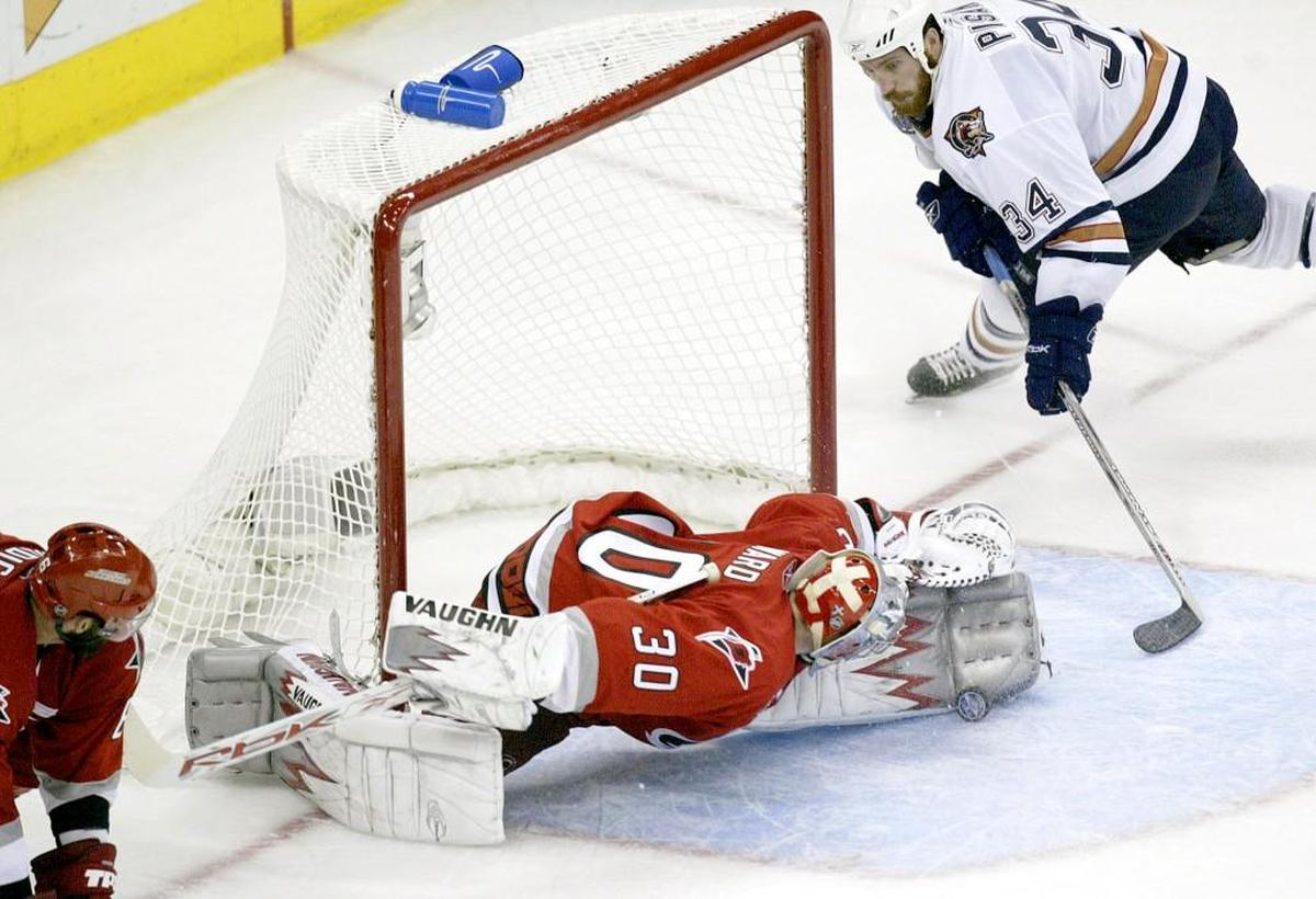 Carolina Hurricanes’ goalie Cam Ward (30), center, blocks a shot by Edmonton Oilers’ Fernando Pisani (34), right, in the third period during game 7 of the Stanley Cup Finals at the RBC Center, June 19, 2006.