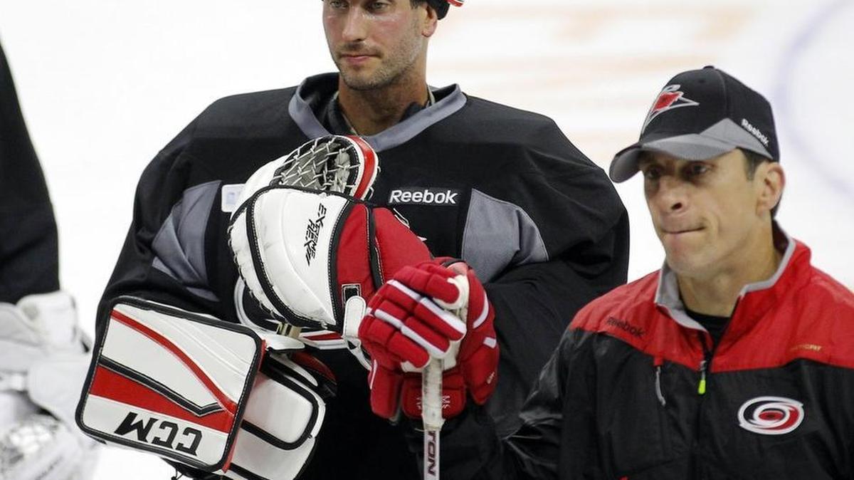 Goaltender Michael Leighton returned to the Carolina Hurricanes in an off-season trade. He stands with assistant coach Rod Brind’Amour as the team holds the first day of on-ice training camp at PNC Arena on Sept. 23.