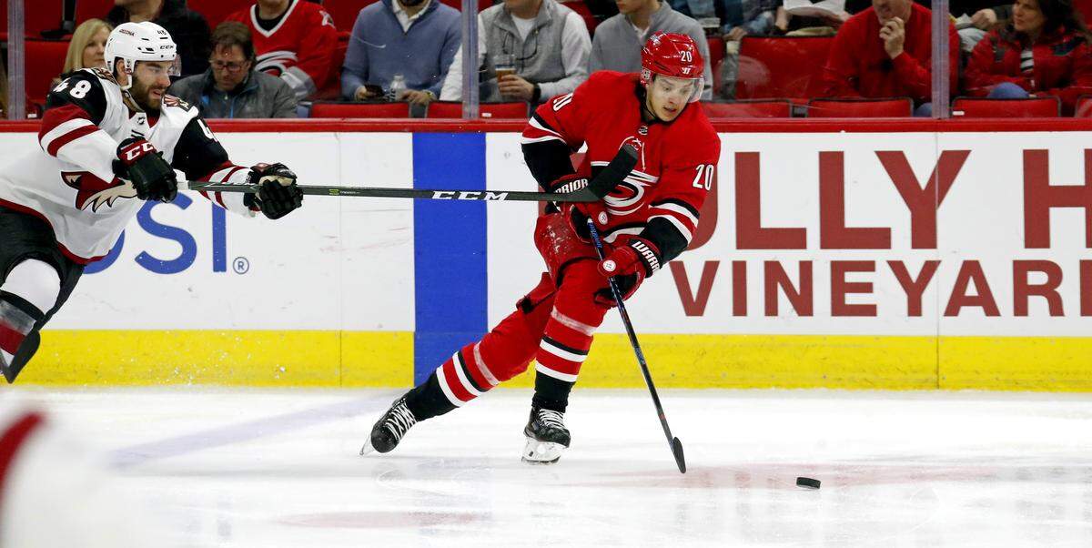 The Canes' Sebastian Aho (20) moves the puck against the Coyotes' Jordan Martinook (48) during the first period of an NHL game played between the Carolina Hurricanes and the Arizona Coyotes at PNC Arena in Raleigh on Thursday, March 22, 2018.