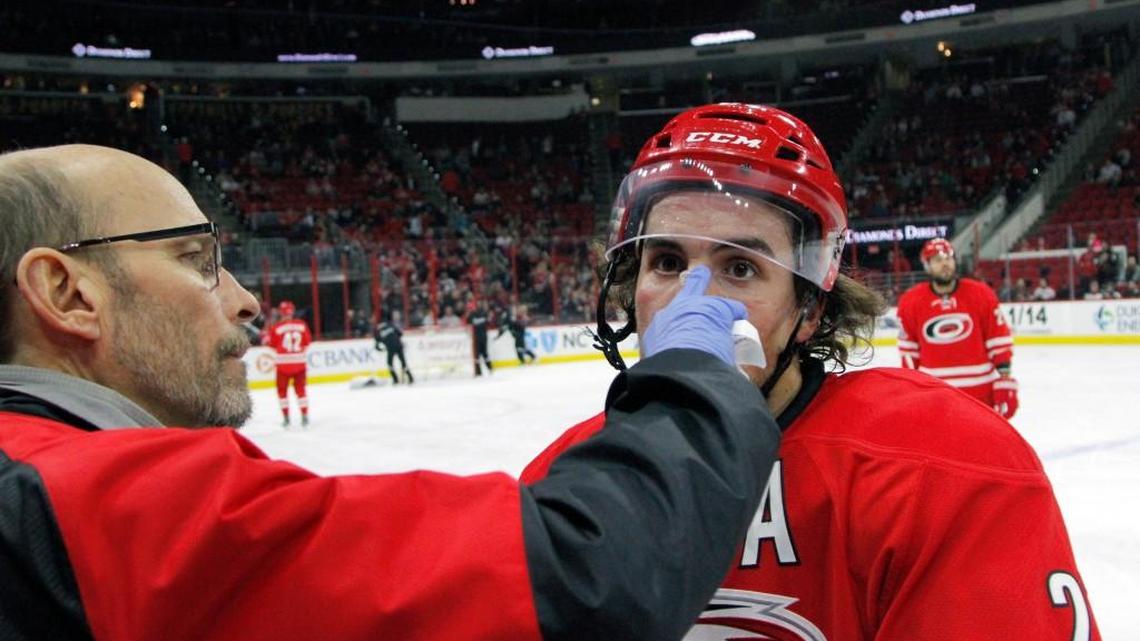Hurricanes head trainer Pete Friesen tends to stitches in Justin Faulk’s nose during a break in the action in the second period of an NHL game played between the Carolina Hurricanes and the Columbus Blue Jackets at PNC Arena in Raleigh, N.C. on Jan. 10, 2017.