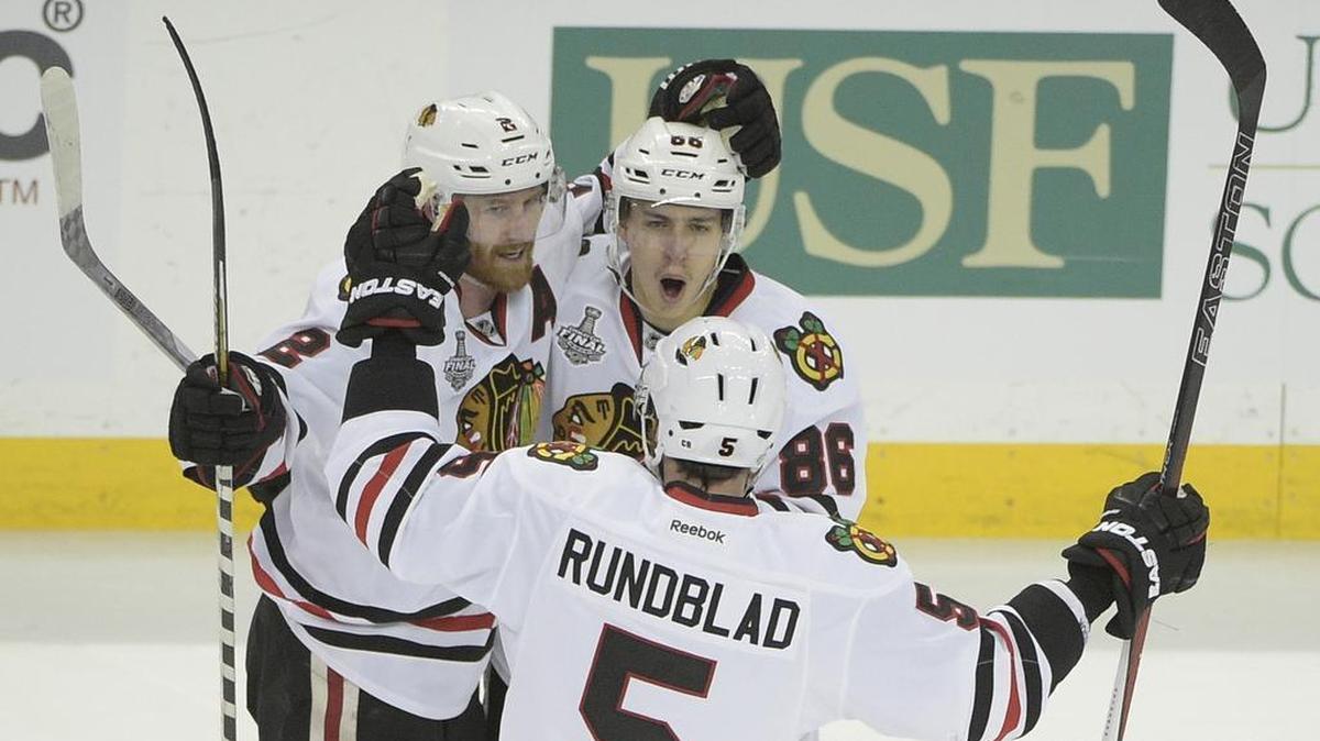 Chicago Blackhawks left wing Teuvo Teravainen (86) of Finland, top right, celebrates his goal with Duncan Keith (2) of Canada, left, and David Rundblad (5) of Sweden, during the third period in Game 1 of the NHL hockey Stanley Cup Final against the Tampa Bay Lightning in Tampa, Fla., Wednesday, June 3, 2015. The Blackhawks won 2-1.