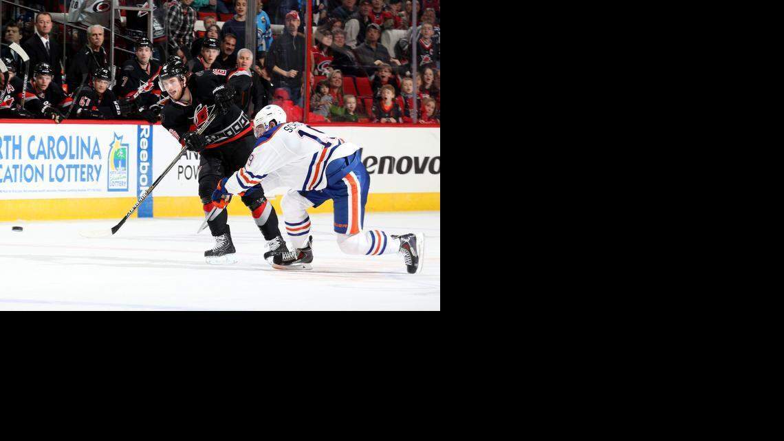 
Elias Lindholm of the Carolina Hurricanes, left, scores an empty-net goal to complete his first NHL career hat trick during a game against the Edmonton Oilers at PNC Arena on Sunday.
