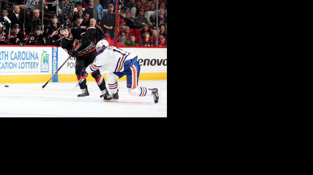 
Elias Lindholm of the Carolina Hurricanes, left, scores an empty-net goal to complete his first NHL career hat trick during a game against the Edmonton Oilers at PNC Arena on Sunday.

