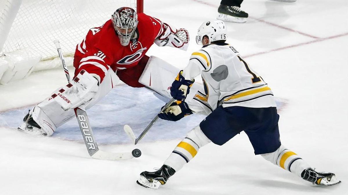 Carolina Hurricanes goalie Cam Ward (30) pokes the puck away from Buffalo Sabres' Jack Eichel (15) to secure the shoot out win.