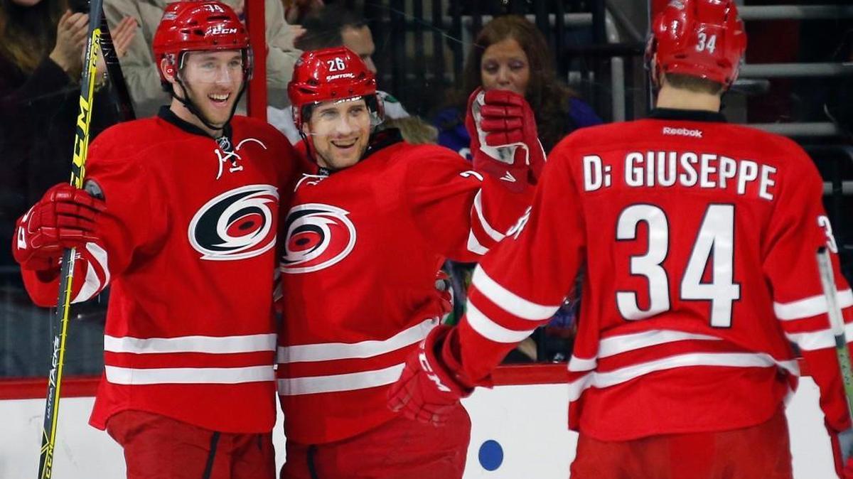 The Carolina Hurricanes' John-Michael Liles (26) celebrates his goal with Jaccob Slavin (74) and Phil Di Giuseppe (34) during the first period of an NHL game played between the Carolina Hurricanes and the Chicago Blackhawks at PNC Arena on Jan. 26.