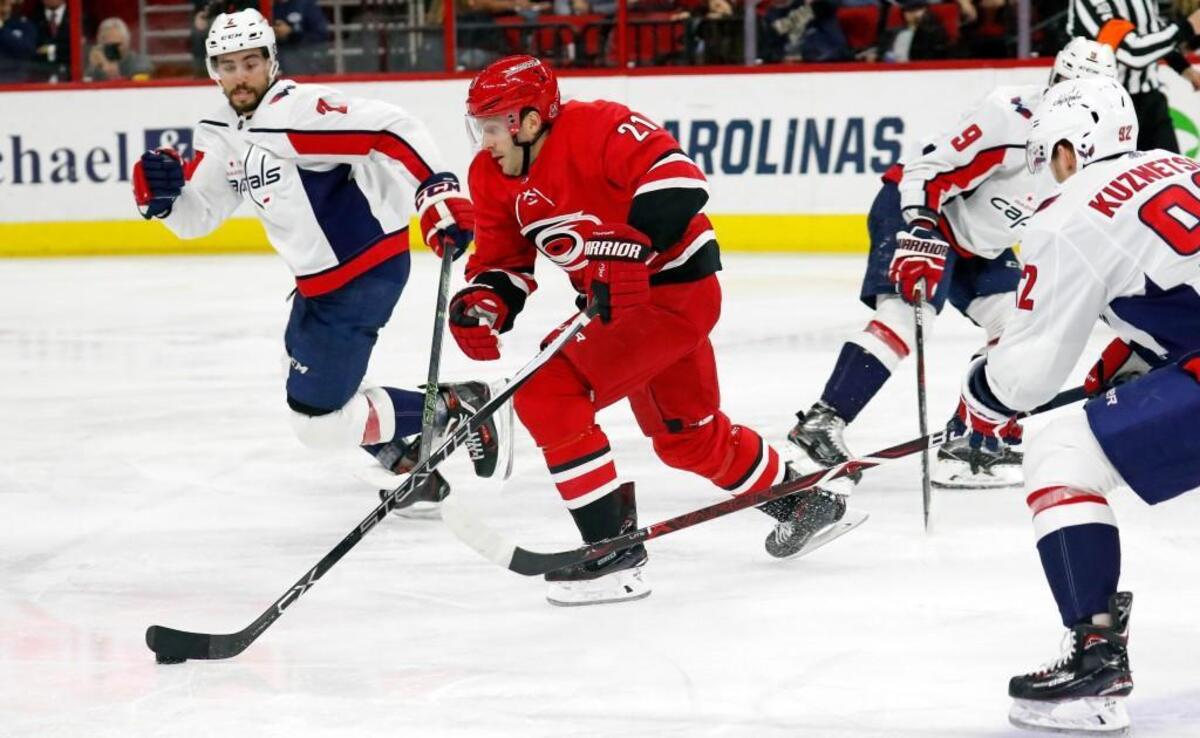 The Canes' Lee Stempniak (21) skates between the Caps' Matt Niskanen (2) and Evgeny Kuznetsov (92) during the second period an NHL game played between the Carolina Hurricanes and the Washington Capitals at PNC Arena in Raleigh, N.C. on Jan. 12, 2018. It was Stempniak's first game of the season; he has been out all year with an injury. The Caps beat the Canes 4-3.