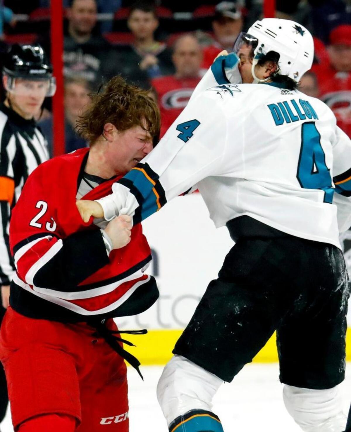 The Canes' Brock McGinn (23) dukes it out with the Sharks' Brenden Dillon (4) during the second period. Both players were penalized for the fight.