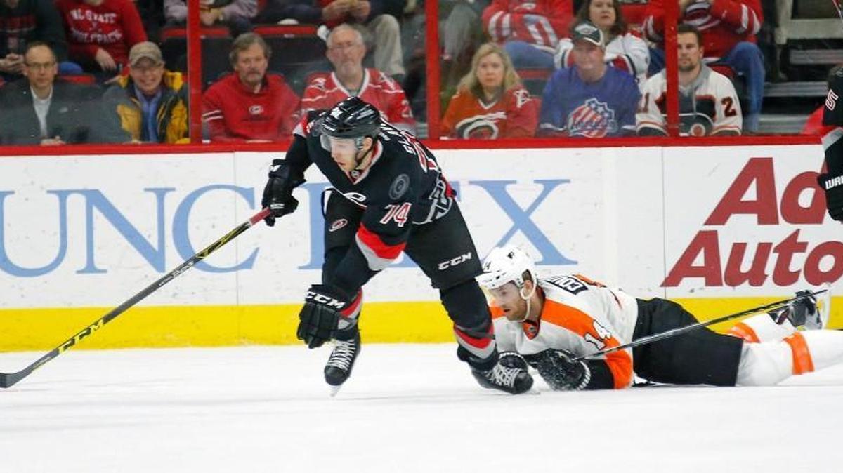 The Carolina Hurricanes' Jaccob Slavin (74) moves the puck against the Philadelphia Flyers' Sean Couturier (14) during the first period of an NHL game played between the Carolina Hurricanes and the Philadelphia Flyers at PNC Arena on Feb. 23.