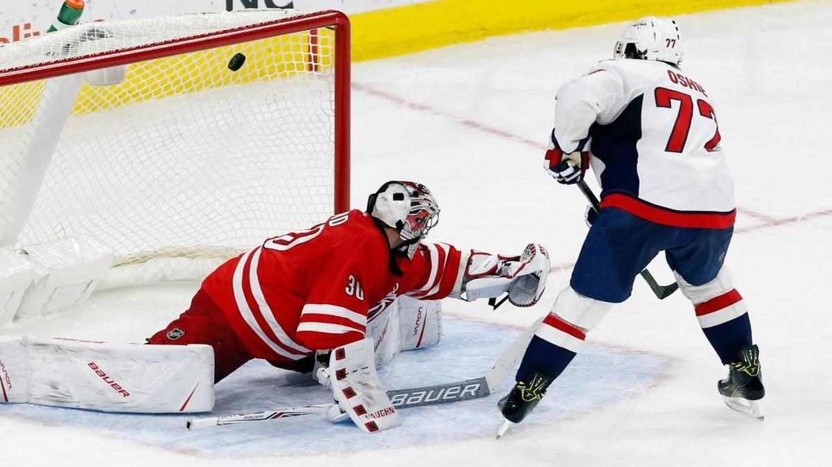 The Washington Capitals' T.J. Oshie puts the puck past the Canes Cam Ward in a shootout at PNC Arena.