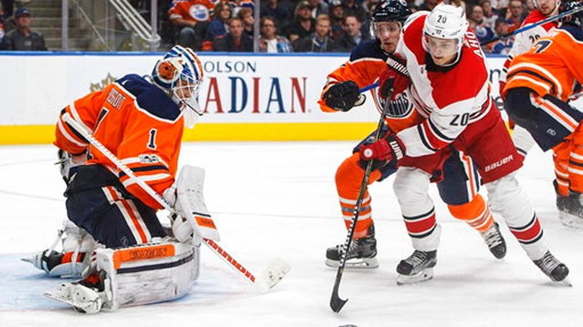 Carolina Hurricanes forward Sebastian Aho (20) is stopped by Edmonton Oilers goalie Laurent Brossoit as Kris Russell (4) defends during the third period of an NHL hockey game in Edmonton, Alberta, Tuesday, Oct. 17, 2017. The Hurricanes won, 5-3.