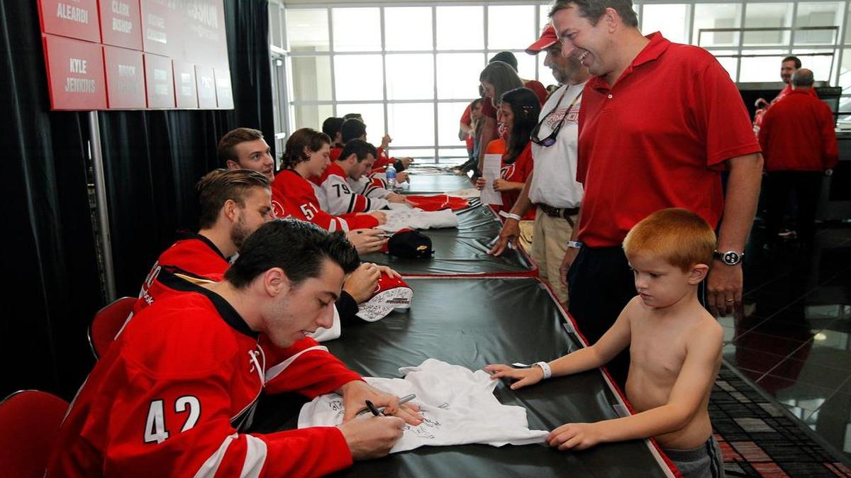 
Trey Sykes, 5, from Raleigh, takes the shirt off his back to get an autograph from Canes prospect Clark Bishop at the Carolina Hurricanes’ Summerfest Celebration held at PNC Arena on July 26, 2014.
