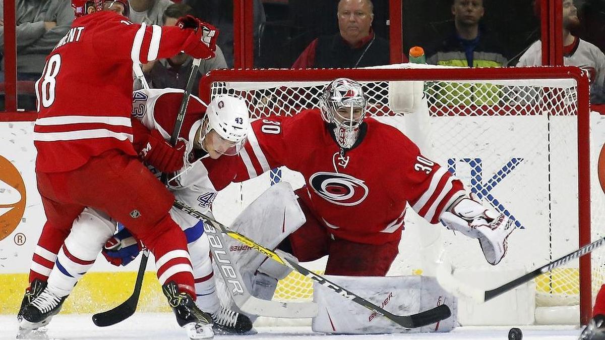 The Canes' Jay McClement (18) and Cam Ward (30) defend the goal against the Montreal Canadiens' Daniel Carr (43) during the first period.