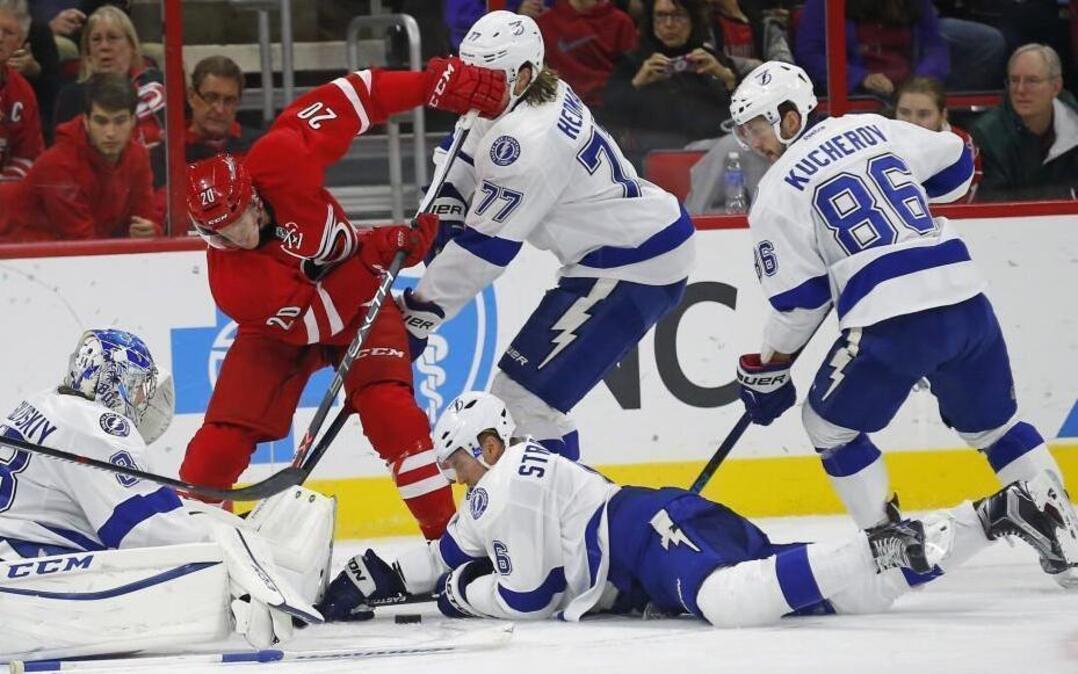 The Carolina Hurricanes' Riley Nash (20) battles the Tampa Bay Lightning's Andrei Vasilevskiy (88), Victor Hedman (77), Anton Stralman (6) and Nikita Kucherov (86) during the second period at PNC Arena in Raleigh,.