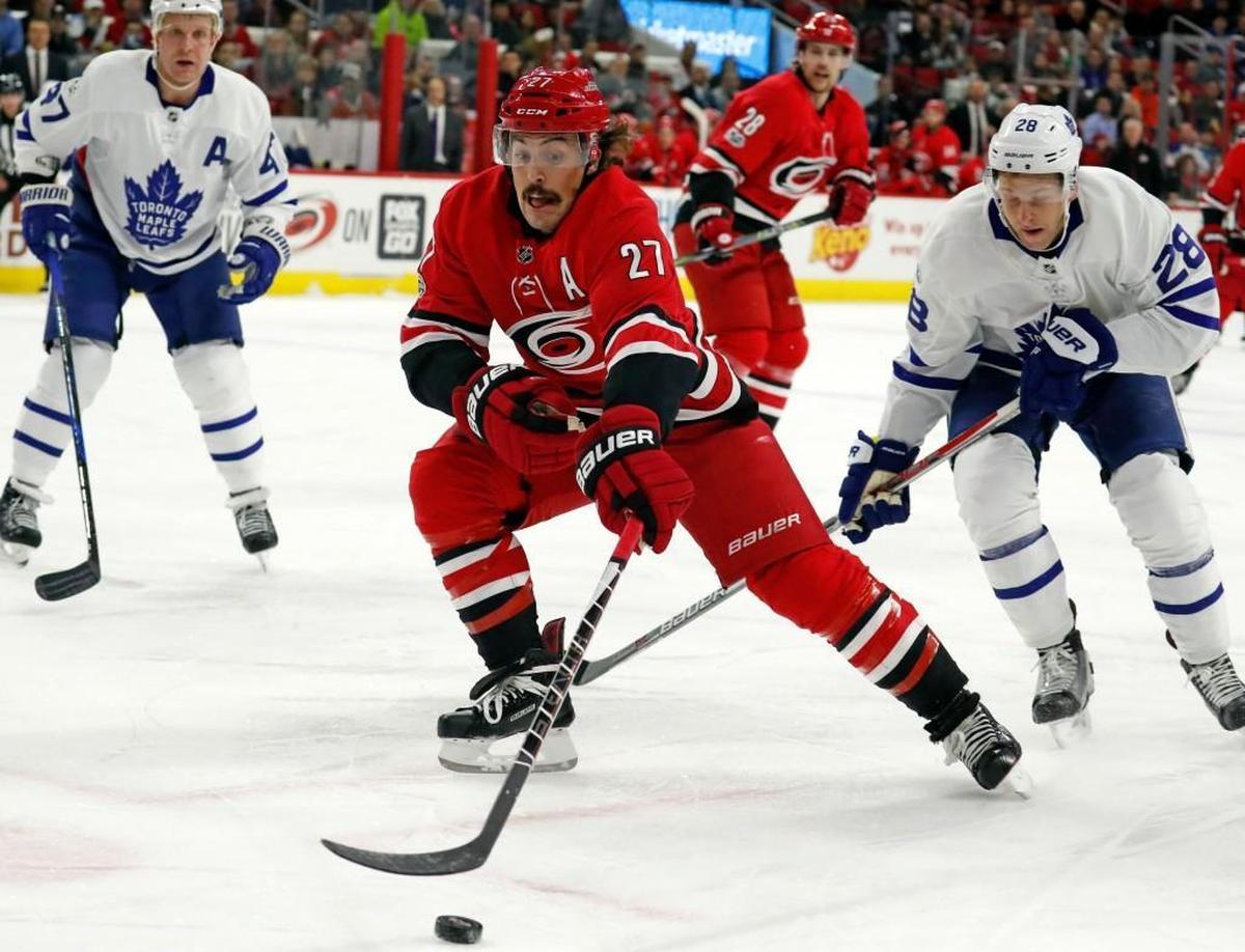 The Canes' Justin Faulk (27) and the Leafs' Connor Brown (28) go for the puck during the first periodat PNC Arena on Nov. 24, 2017.