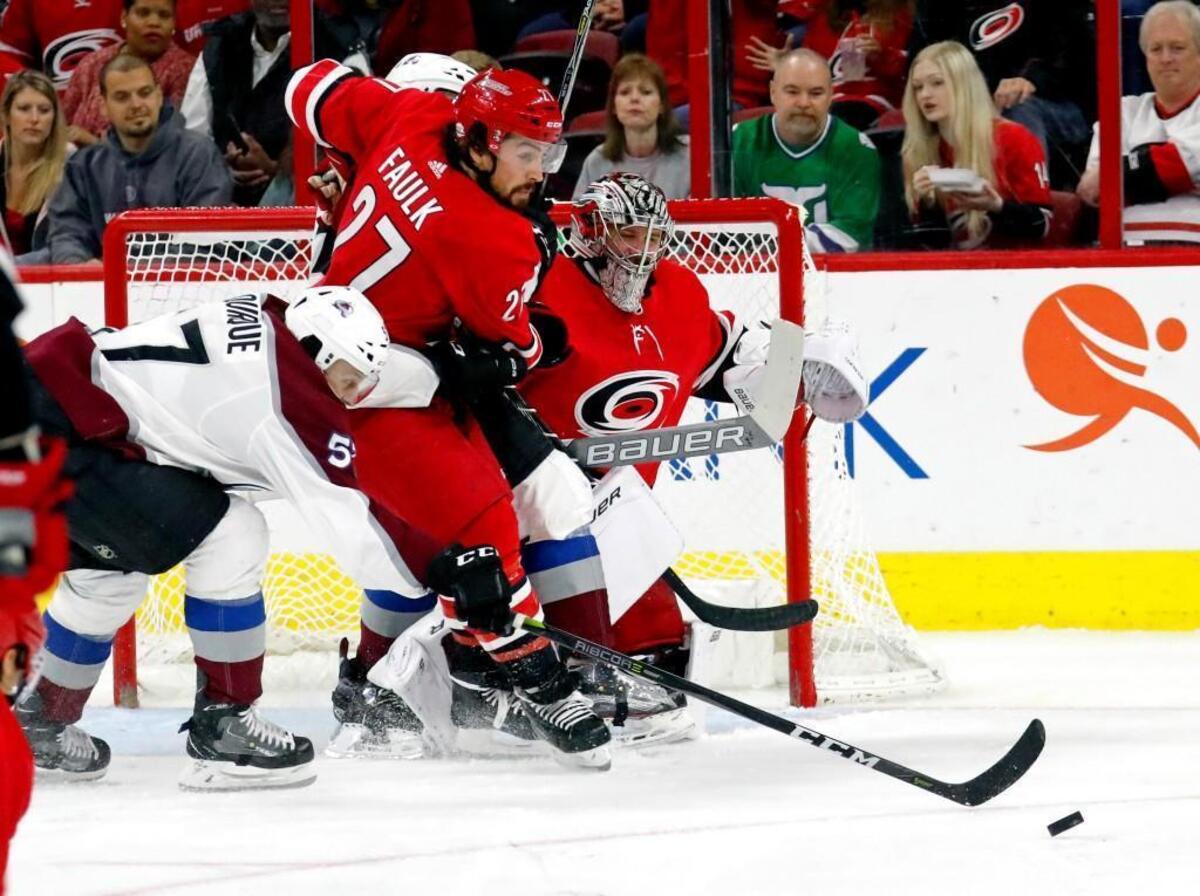The Canes' Justin Faulk (27) and Cam Ward (30) defend the net against the Avs' Gabriel Bourque (57) during the second period of an NHL game played between the Carolina Hurricanes and the Colorado Avalanche.