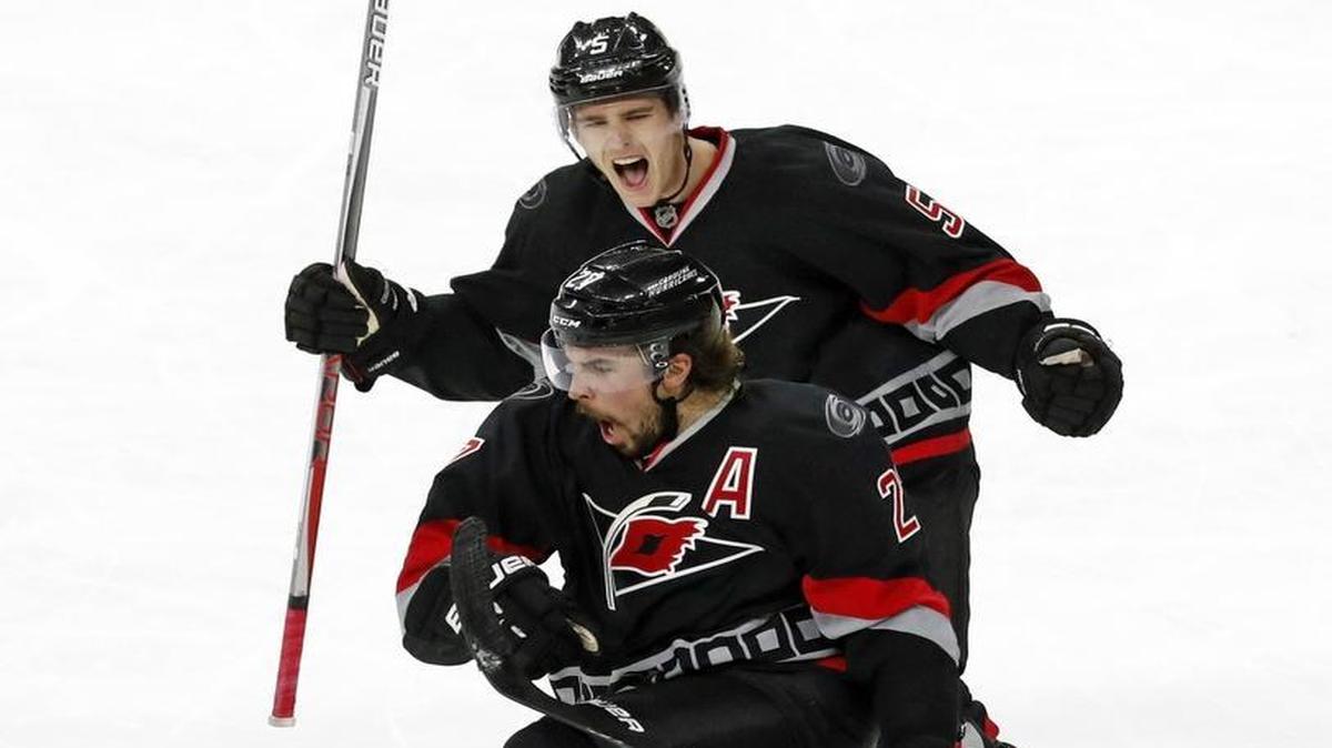 The Canes' Justin Faulk (27) celebrates his goal with Noah Hanifin (5) during the third period of an NHL game played between the Carolina Hurricanes and the Detroit Red Wings at PNC Arena on Monday night.