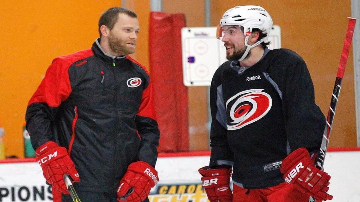 Former Carolina Hurricanes defenseman Tim Gleason , left, talks with Justin Faulk after a Canes practice. Gleason has been hired as the team's director of defensemen development.