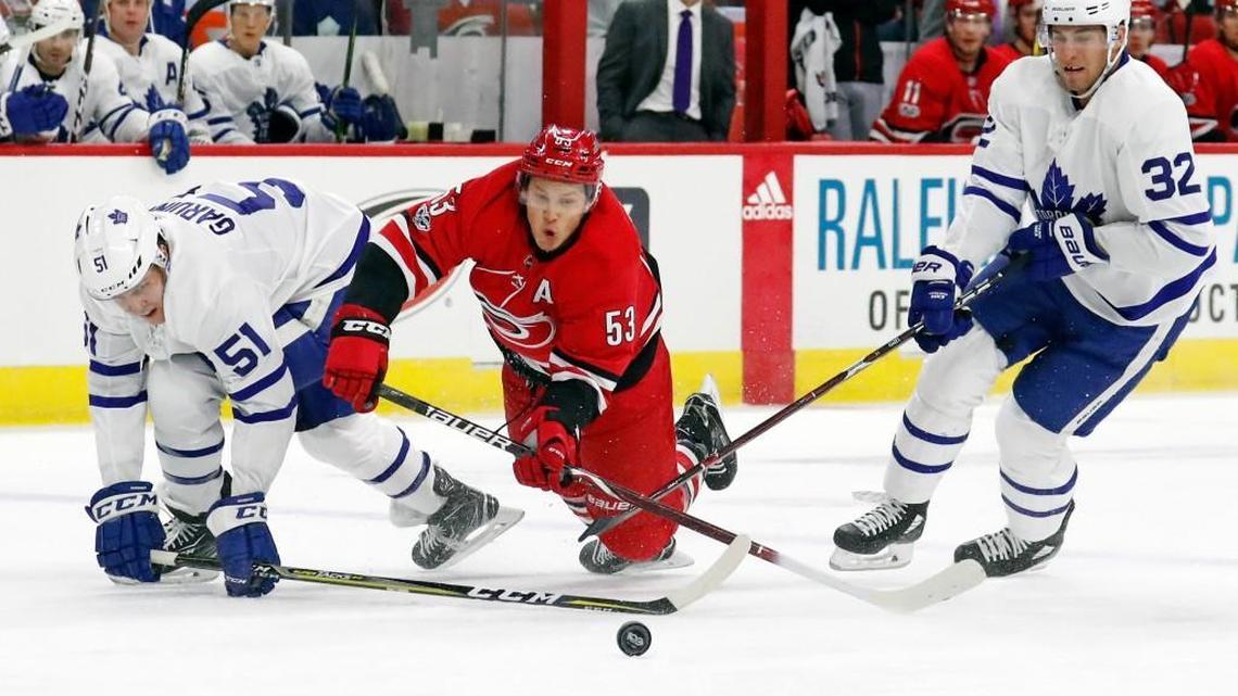The Canes’ Jeff Skinner (53) battles the Leafs’ Jake Gardiner (51) and Josh Leivo (32) as they go for the puck during the first period. Toronto was called for a penalty on the play.