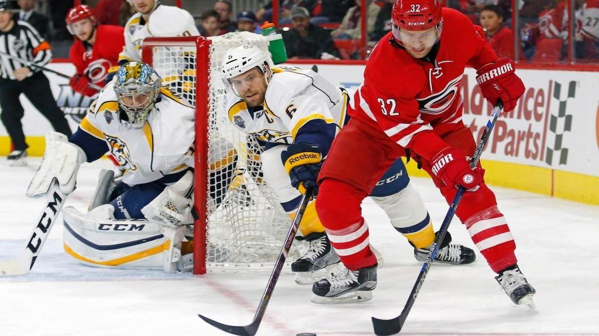 The Carolina Hurricanes' Kris Versteeg (32) works the puck against the Nashville Predators' Pekka Rinne (35) and Shea Weber (6) during the Predators’ 2-1 overtime win on Jan. 2.