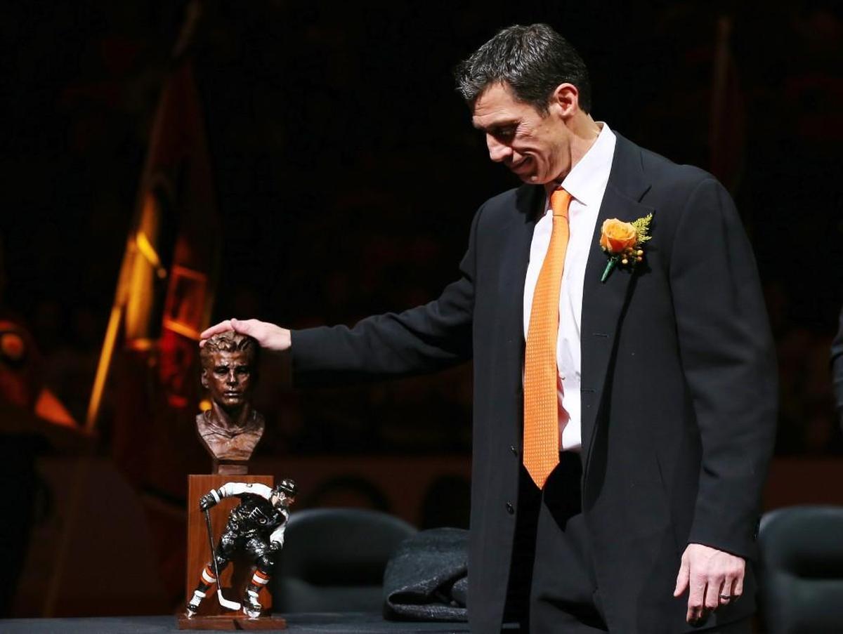 Former Flyer Rod Brind’Amour stands next to his statue during the Flyers’ Hall of Fame induction ceremony Monday before the game between Philadelphia and Carolina at the Wells Fargo Center in Philadelphia. Now an assistant coach with Carolina, Brind’Amour won the Stanley Cup with the 2006 Hurricanes.