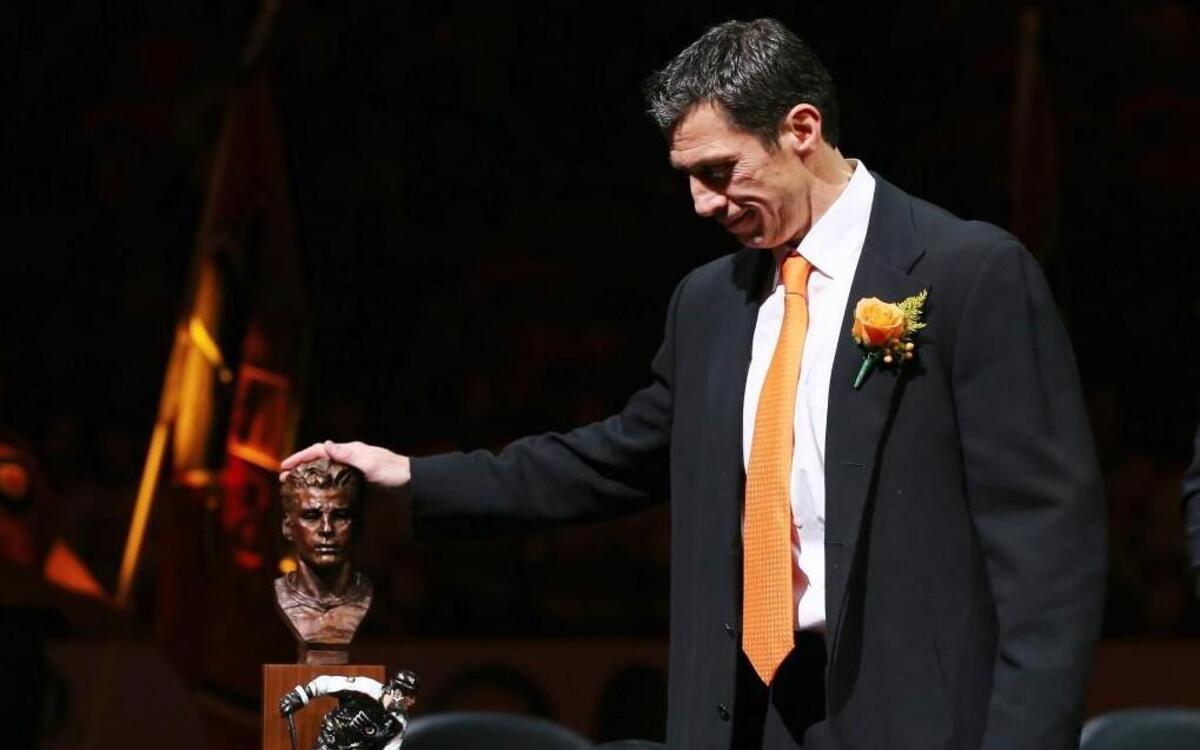 Former Flyer Rod Brind’Amour stands next to his statue during the Flyers’ Hall of Fame induction ceremony Monday before the game between Philadelphia and Carolina at the Wells Fargo Center in Philadelphia. Now an assistant coach with Carolina, Brind’Amour won the Stanley Cup with the 2006 Hurricanes.