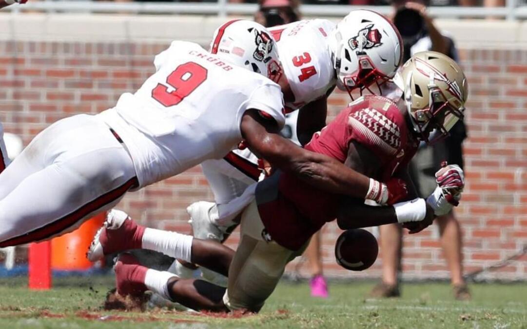 N.C. State defensive end Bradley Chubb (9) causes Florida State quarterback James Blackman (1) to fumble at Doak Campbell Stadium in Tallahasee Saturday. N.C. State safety Tim Kidd-Glass (34) is also in on the play. The Wolfpack would recover the fumble.