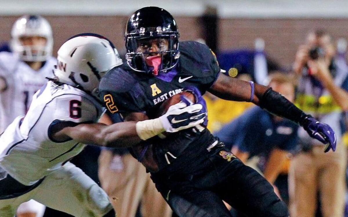 
East Carolina Pirates's Justin Hardy (2) tries to break free from the grasp of the Connecticut Huskies's Jhavon Williams (6) during an NCAA college football game played between East Carolina Pirates and the Connecticut Huskies at Dowdy-Ficklen Stadium in Greenville, N.C. on Oct. 23, 2014. ECU beat UConn 31-21.
