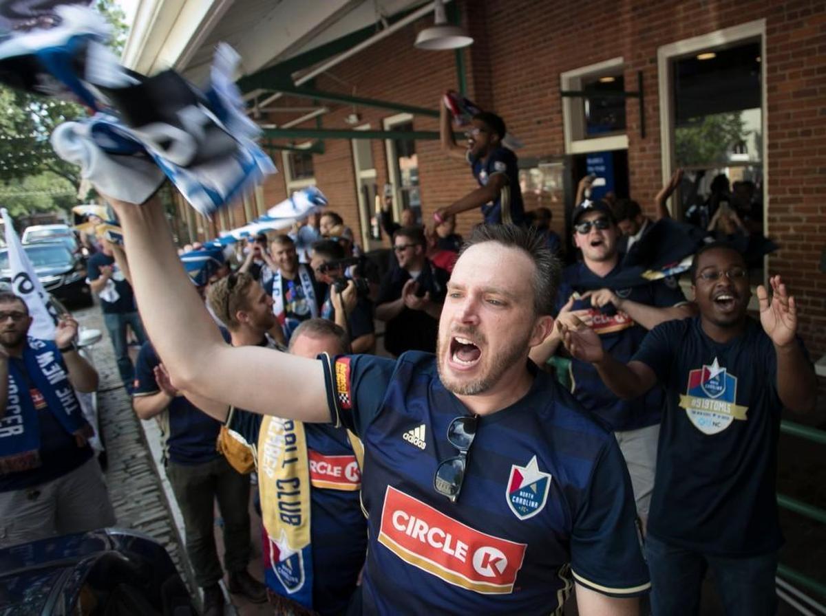 Chuck Givens leads the chants as a group of soccer fans arrive at City Market in downtown Raleigh after a march from London Bridge Pub on Hargett Street to a rally to promote Raleigh as a MLS expansion city on Wednesday.