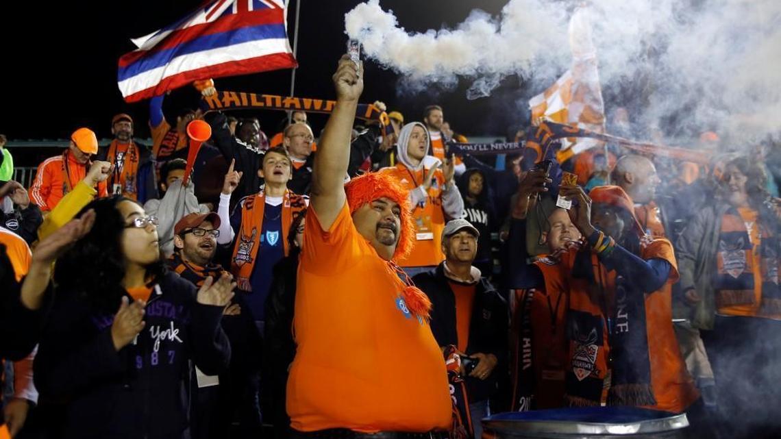RailHawks fan Jaime Vargas holds up a smoke-maker as time expires during the Carolina RailHawks' season-opening home game against the Ft. Lauderdale Strikers at WakeMed Soccer Park in Cary on Saturday, April 19, 2014. "I'm the one in charge of smoke," said Vargas. The RailHawks won the game 4-1.