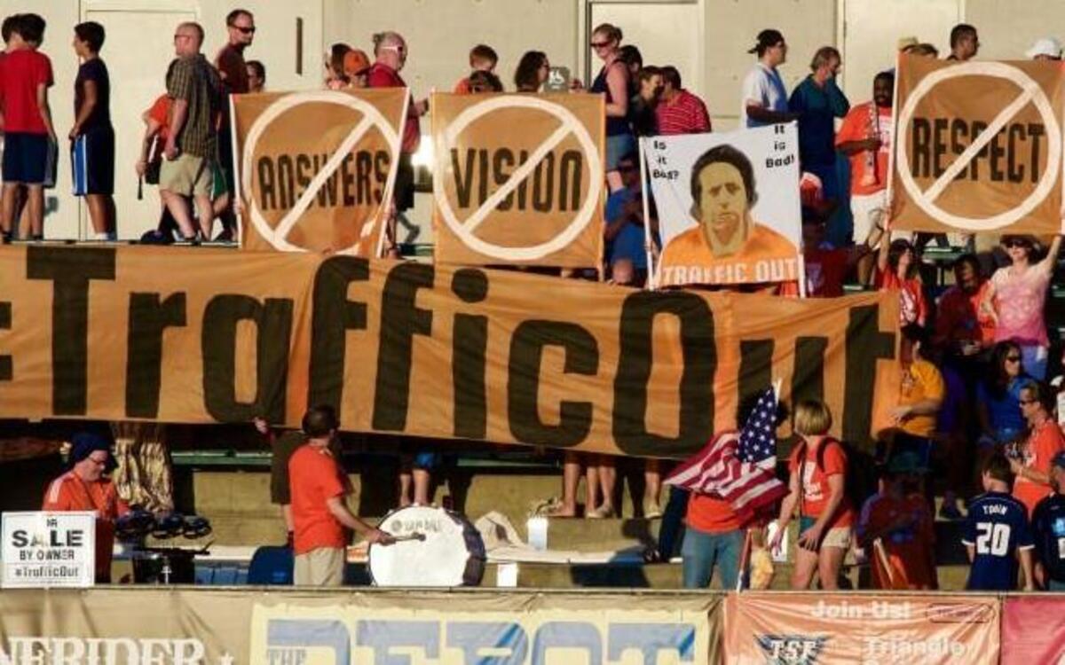
RailHawks fans protest the team’s current owner, Traffic Sports USA, at home matches with signs including depicting indicted Traffic president Aaron Davidson.
