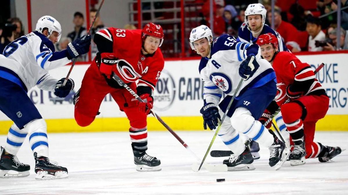 The Canes' Jeff Skinner (53) and Derek Ryan (7) battle the Jets' Blake Wheeler (26), Mark Scheifele (55) and Josh Morrissey (44) for the puck during the second period of an NHL game played between the Carolina Hurricanes and the Winnipeg Jets at PNC Arena in Raleigh, N.C. on March 4, 2018.