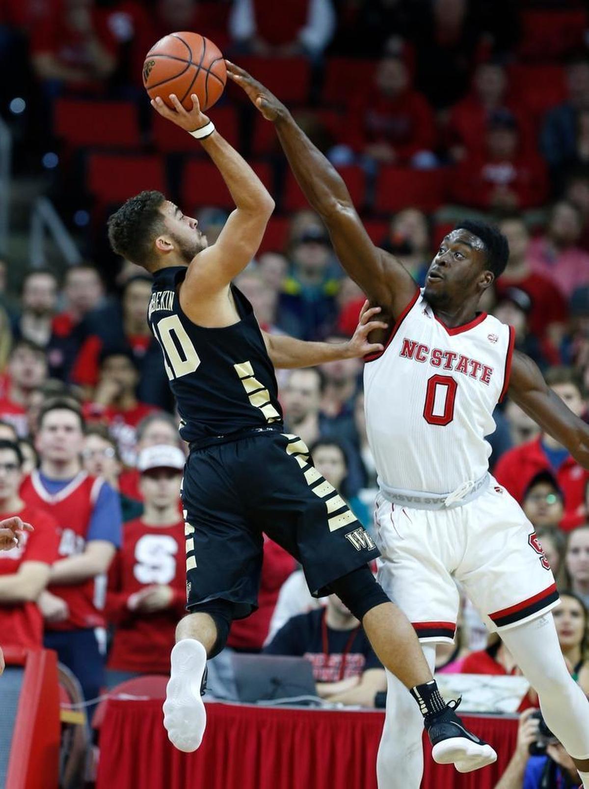 N.C. State's Abdul-Malik Abu (0) blocks the shot by Wake Forest's Mitchell Wilbekin (10) during the first half of N.C. State's game against Wake Forest at PNC Arena on Thursday, Jan. 18, 2018.