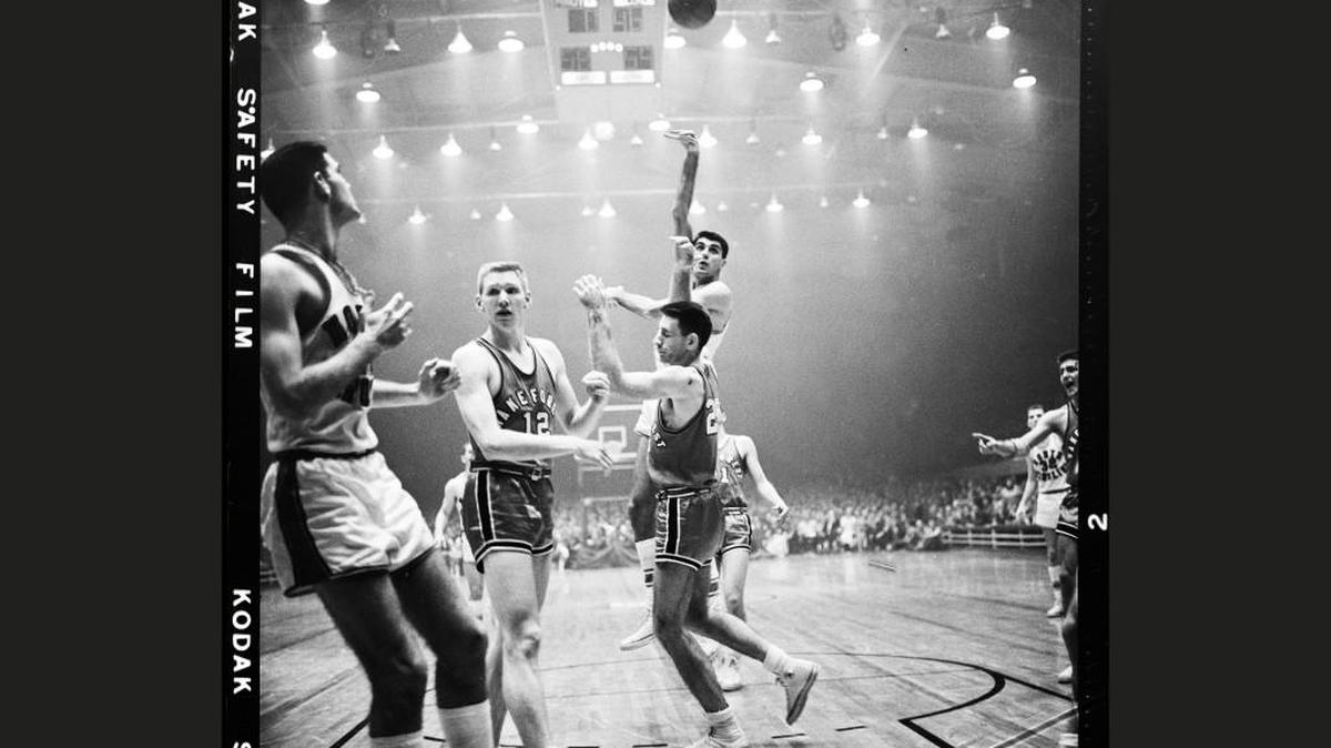 Lennie Rosenbluth shoots over Wake Forest defenders in the 1957 ACC Tournament. A haze of cigarette and cigar smoke hangs in the air as was often the case in Reynolds before smoking was banned from the arena decades later.