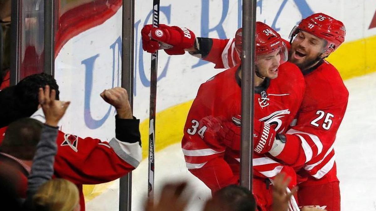 Carolina Hurricanes' Phillip Di Giuseppe (34) is congratulated by teammate Viktor Stalberg (25) following his game-winning overtime goal against the Tampa Bay Lightning.