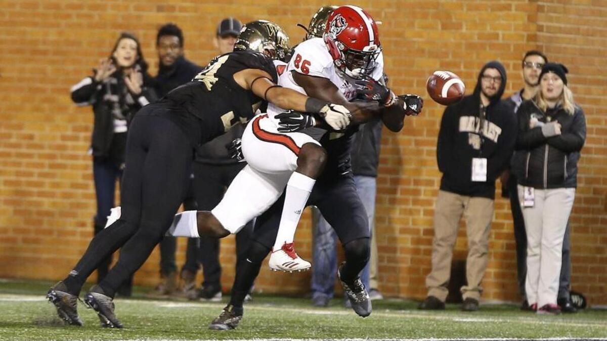 N.C. State wide receiver Emeka Emezie (86) fumbles the ball before crossing into the end zone as he is hit by Wake Forest's Demetrius Kemp (34), left, and Ja'Sir Taylor (24) during the second half of Wake Forest's 30-24 victory over N.C. State at BB&T Field in Winston-Salem, N.C., Saturday, Nov. 18, 2017.