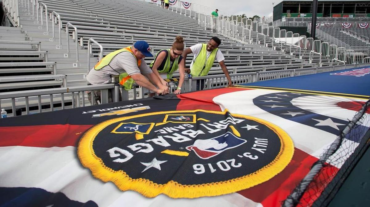 Dave Wilson, Catherine Bielski, and Ephrem Michael install banners on the Atlanta Braves’ dugout as construction crews make final preparations on Thursday, June 30, 2016 for the major league game between the Atlanta Braves and the Florida Marlins to be played on base at Ft. Bragg on Sunday, July 3.