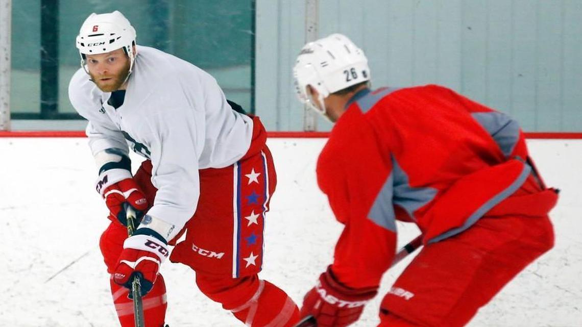 Former Carolina Hurricane Tim Gleason, left, moves the puck near the Canes' John-Michael Liles during an informal workout session before the 2015 training camp. .
