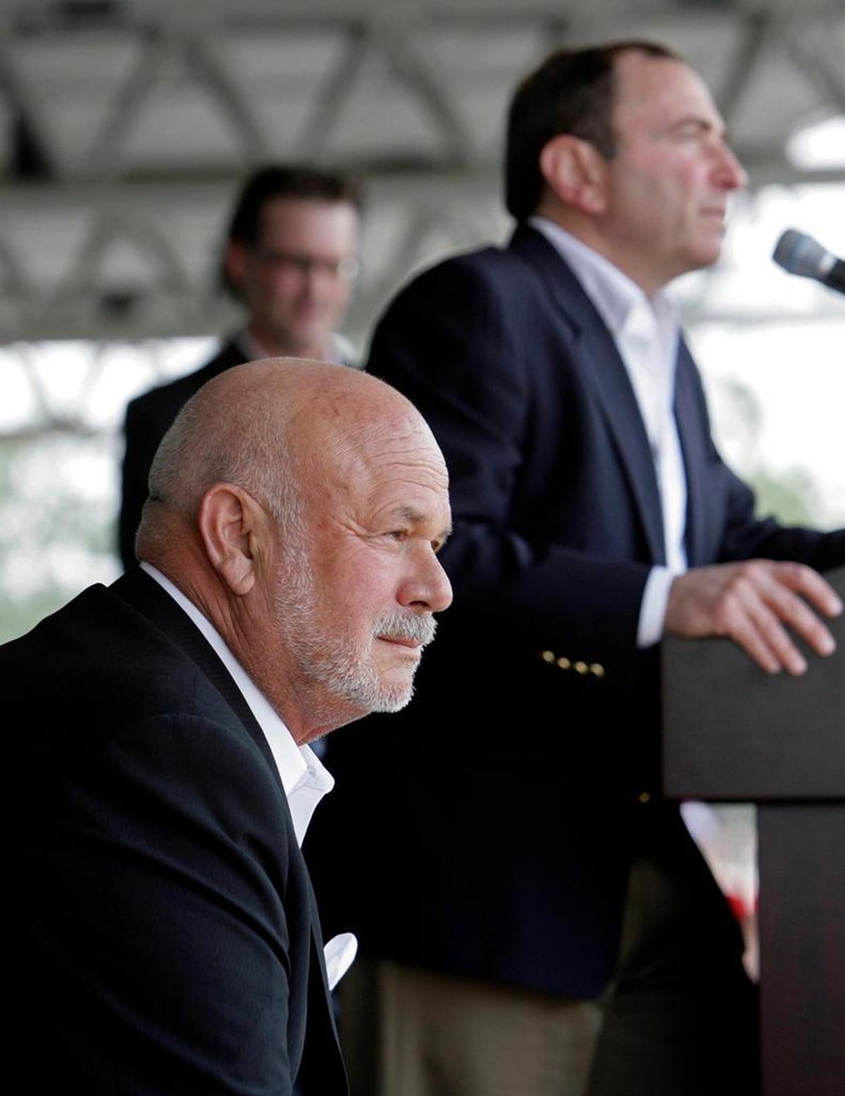Carolina Hurricanes owner Peter Karmanos Jr., left, listens as NHL Commissioner Gary Bettman speaks at an NHL All Star game event at PNC Arena in 2010.