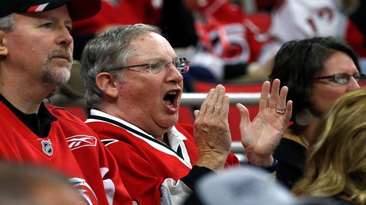 The Canes longest-running season ticket holder Larry Putman, center, watches with his friend Marty Kellam, left, during an NHL preseason game against the Tampa Bay Lightning at the PNC Arena on September. 30. Putnam has had season tickets since the team's early days when they played in Greensboro.