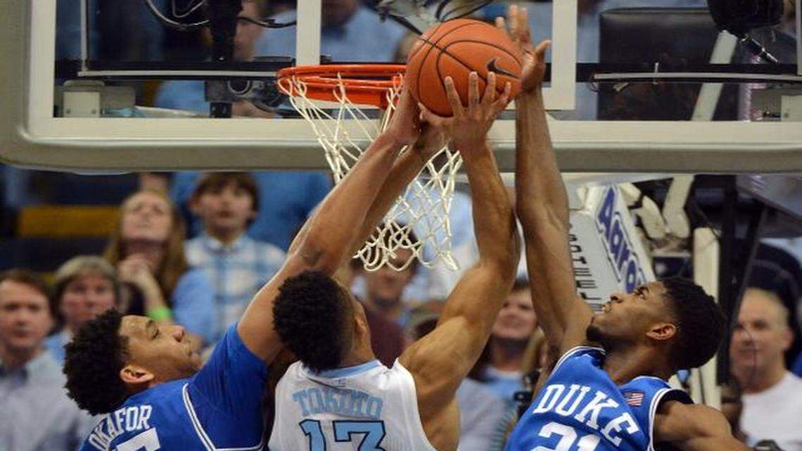
Duke’s center Jahlil Okafor (15) and Amile Jefferson (21) block a first-half shot by UNC’s J.P. Tokoto at the Dean Smith Center in Chapel Hill.
