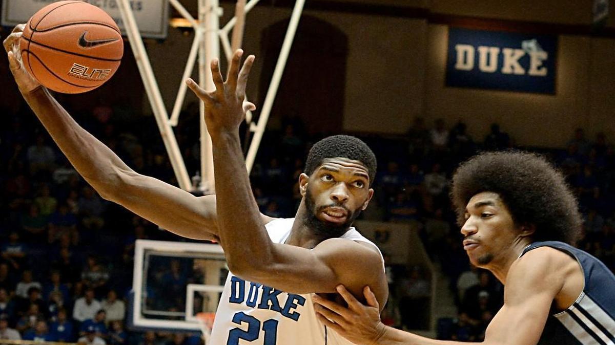 Duke forward Amile Jefferson (21) moves the ball past Utah State forward Jalen Moore (14) in the first half of play as he heads towards the basket. Duke defeated Utah State 85-52 at Cameron Indoor Stadium, Sunday, November 29, 2015 in Durham, N.C.