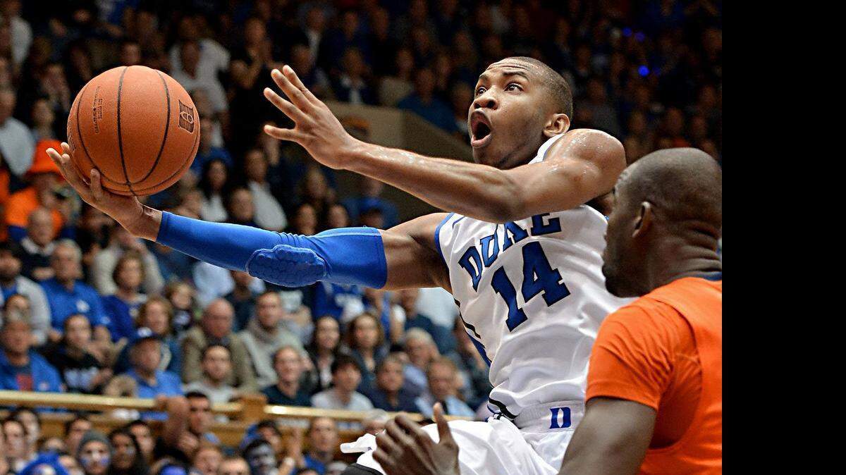 
Rasheed Sulaimon  scores in the second half as Syracuse center Baye Moussa Keita  defends.The former Duke guard is transferring to Maryland, where he can play immediately if he graduates from Duke in August. 
