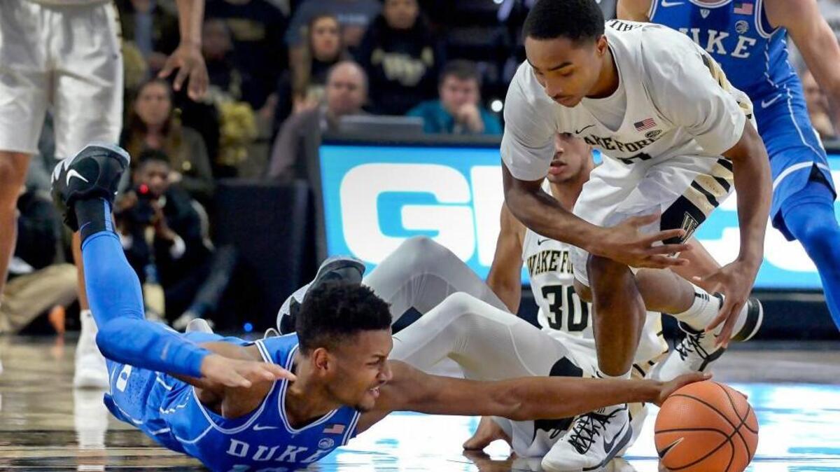 Duke forward Javin DeLaurier (12) goes a for a steal from Wake Forest guard Brandon Childress (0) during the first half.