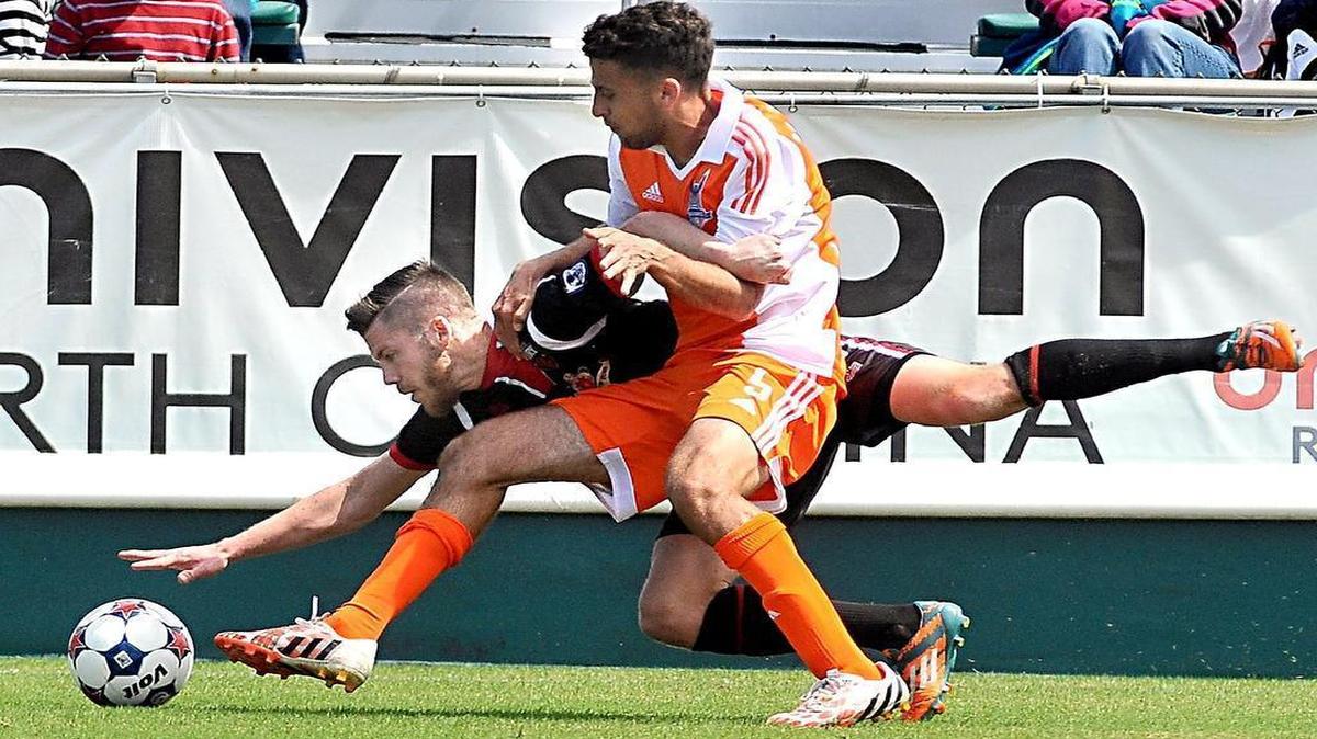 
The Carolina RailHawks' Nazmi Albadawi (5) and Ottawa Fury's Carl Haworth (17) battle for control of the ball in the RailHawks' season opener at the WakeMed Soccer Park in Cary, N.C. on April 4, 2015.
