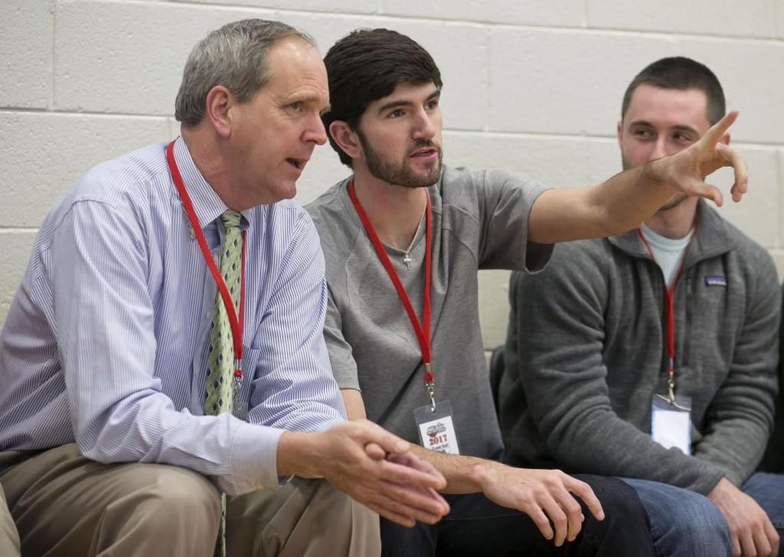 Scott Dupree, left, the executive director of the Greater Raleigh Sports Alliance, and his son Davis Dupree, center, take in a game during the John Wall Family Foundation Holiday basketball tournament on Wednesday.