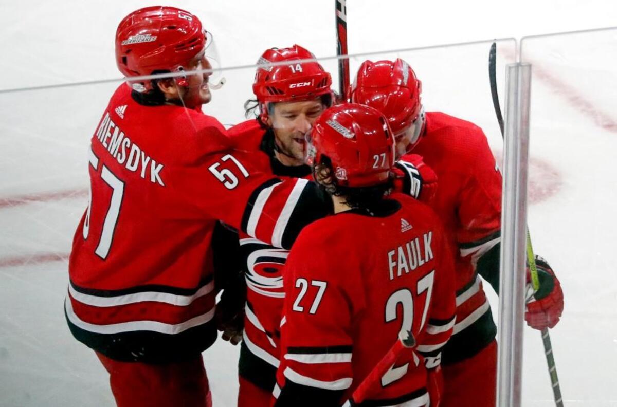 The Canes' Justin Williams (14) celebrates his goal with Trevor van Riemsdyk (57), Justin Faulk (27) and Derek Ryan (7) during the third period.