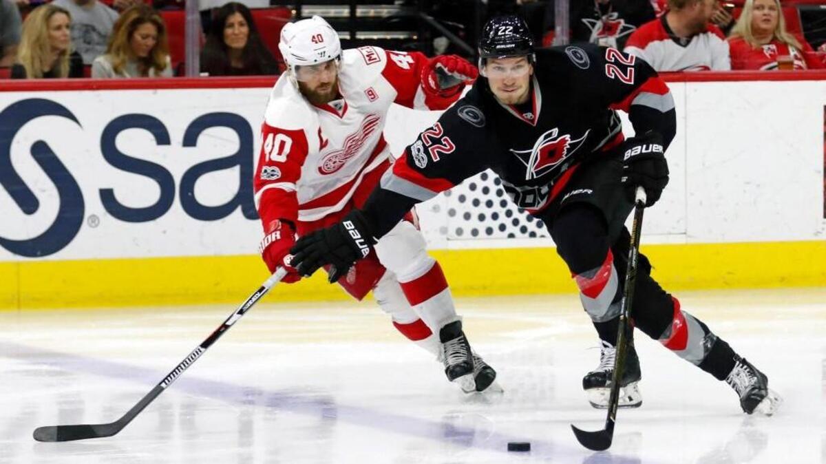 The Canes' Brett Pesce (22) moves the puck against the Detroit Red Wings' Henrik Zetterberg (40) at PNC Arena on March 27, 2017.